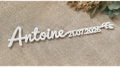 Marque-place « Antoine » avec la date 21.07.2026, en blanc, sur une toile de lin.